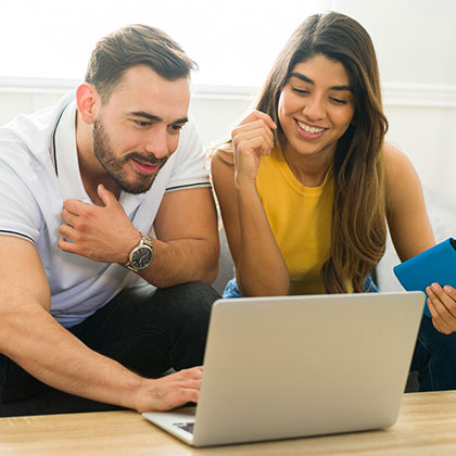 Young couple looking at laptop in living room